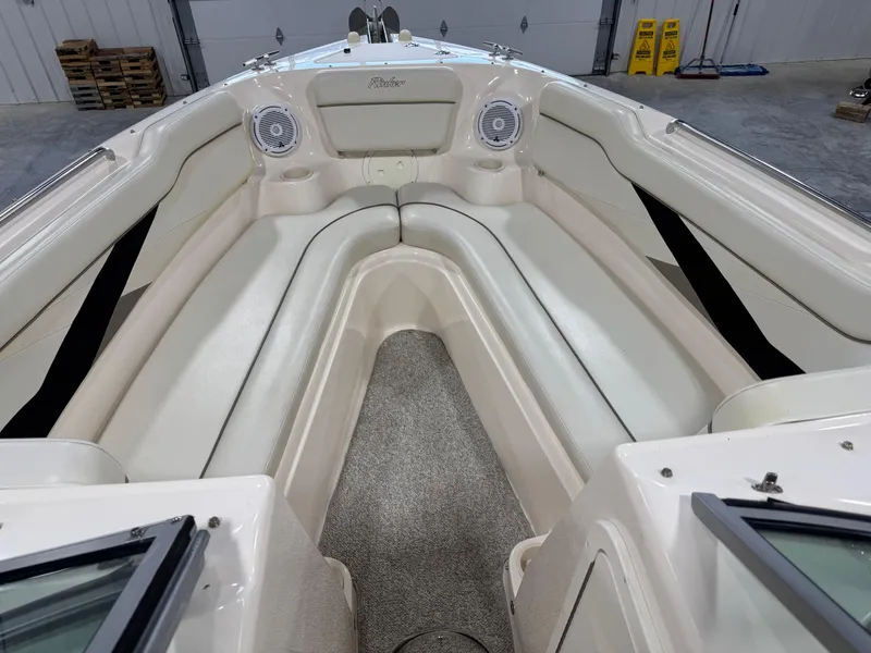 Slide: The Image of 2005 Rinker 282 Captiva Bowrider interior with white seating and speakers. - 12