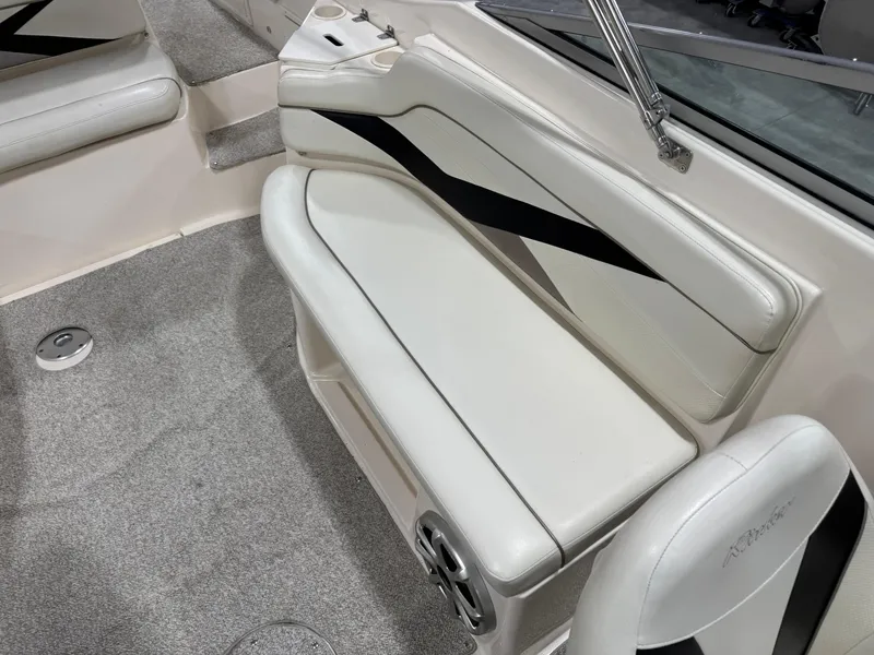 Slide: The Image of 2005 Rinker 282 Captiva Bowrider interior with white seating and black accents. - 8