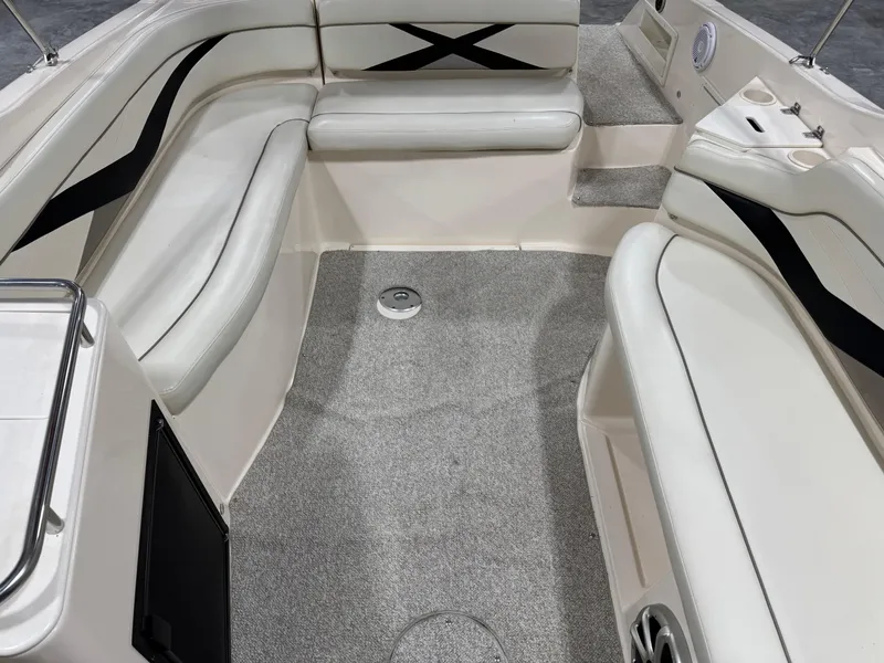 Slide: The Image of 2005 Rinker 282 Captiva Bowrider interior with white seating and gray carpet. - 9