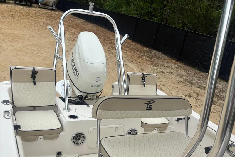 Slide: The Image of 2021 Carolina Skiff 19 LS boat interior with Suzuki engine, featuring cushioned seating and stainless steel rails. - 10