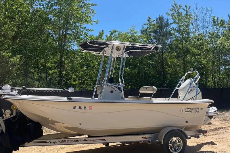 Slide: The Image of 2021 Carolina Skiff 19 LS boat on trailer, surrounded by trees. - 3