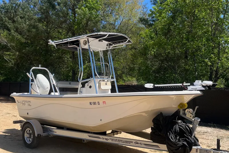 Slide: The Image of 2021 Carolina Skiff 19 LS boat on trailer, parked outdoors with trees in background. - 4