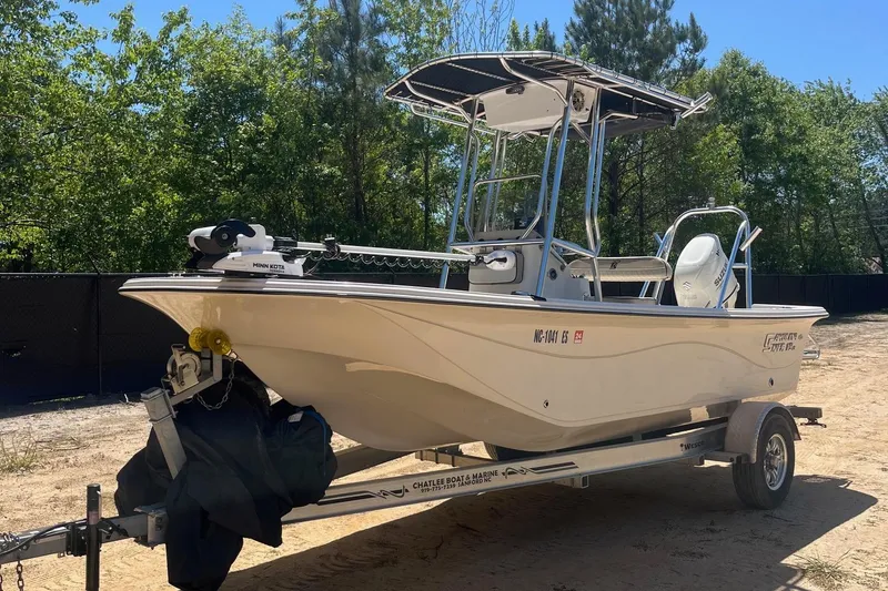 Slide: The Image of 2021 Carolina Skiff 19 LS boat on trailer, parked outdoors with trees in the background. - 5