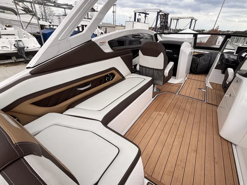 Slide: The Image of 2021 Yamaha Boats 275 SD interior with luxurious seating and teak flooring. - 10