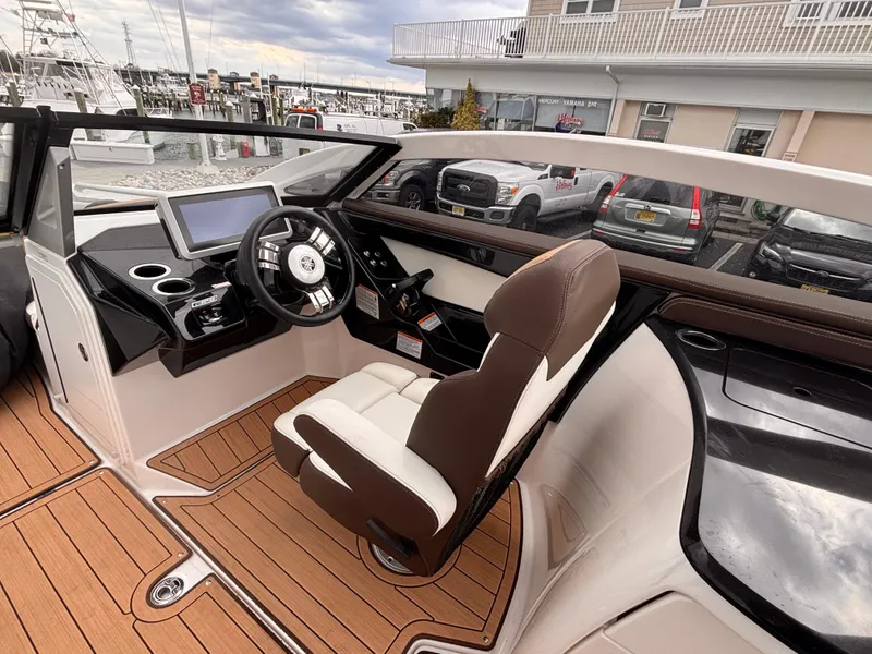 Slide: The Image of 2021 Yamaha Boats 275 SD cockpit with modern steering, touchscreen, and luxurious seating. - 14