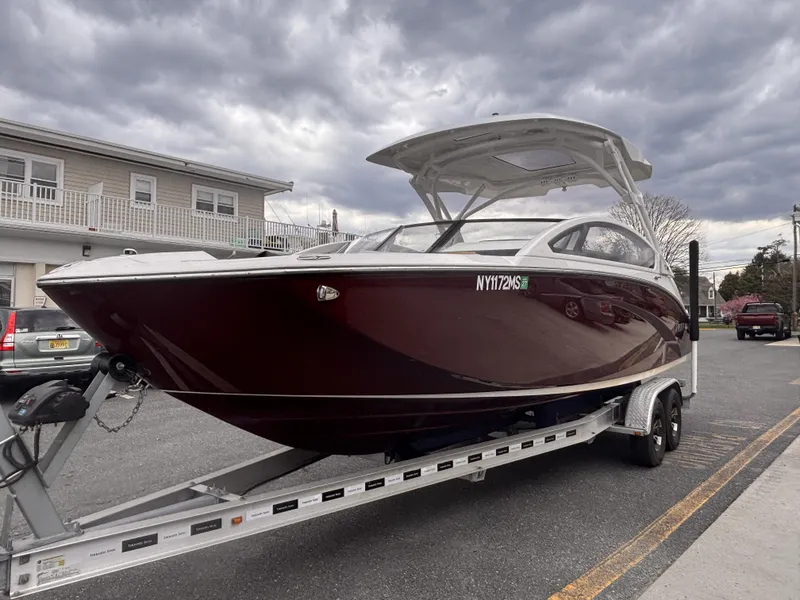 Slide: The Image of 2021 Yamaha Boats 275 SD on trailer, parked on street under cloudy sky. - 2