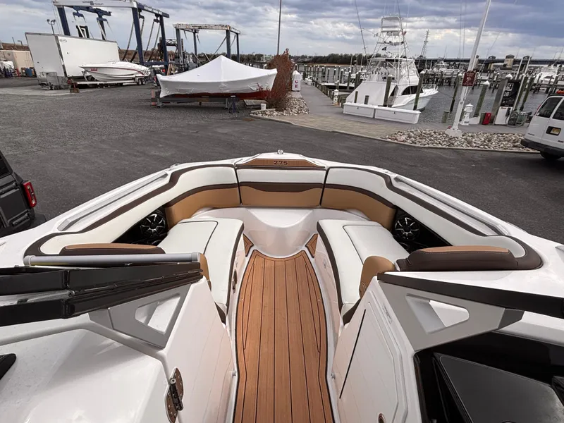 Slide: The Image of 2021 Yamaha Boats 275 SD with spacious seating at a marina. - 20