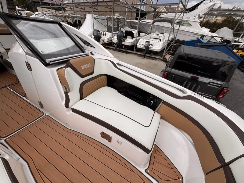 Slide: The Image of 2021 Yamaha Boats 275 SD interior with cushioned seating and sleek design. - 21