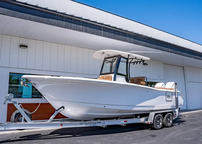 Slide: The Image of 2025 Sea Hunt Ultra 265 SE boat on trailer outside a building. - 1