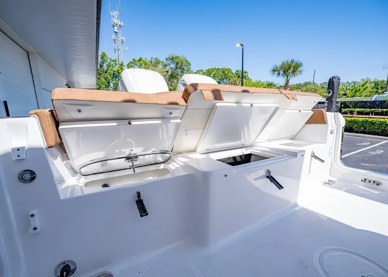 Slide: The Image of 2025 Sea Hunt Ultra 265 SE boat interior with open storage compartments and cushioned seating. - 10