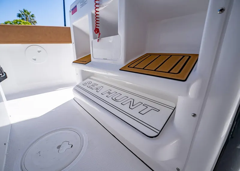 Slide: The Image of 2025 Sea Hunt Ultra 265 SE boat interior with branded step and teak accents. - 23