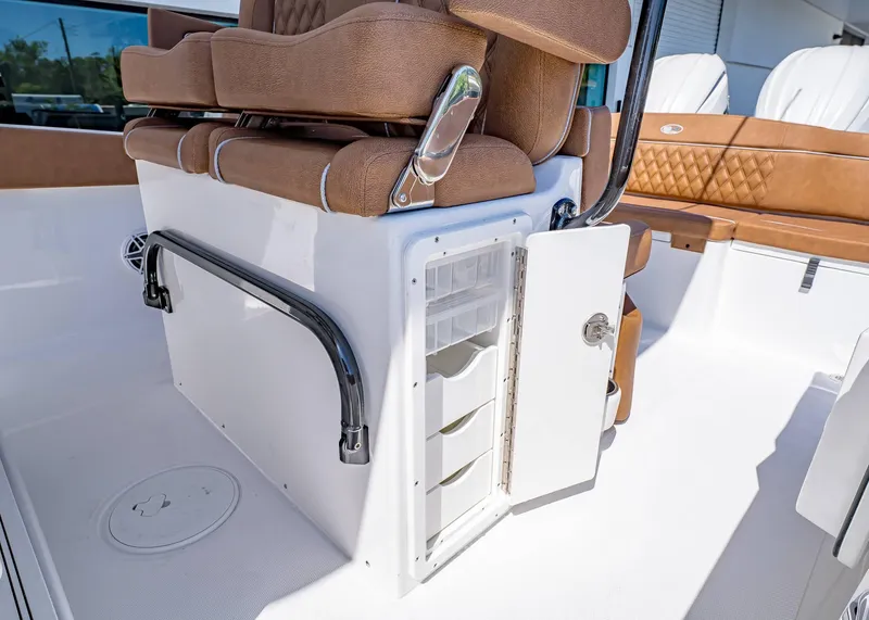 Slide: The Image of 2025 Sea Hunt Ultra 265 SE boat interior with open storage compartment and cushioned seating. - 25