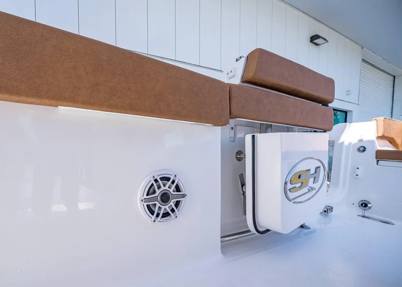 Slide: The Image of 2025 Sea Hunt Ultra 265 SE boat interior with brown seating and speaker detail. - 30