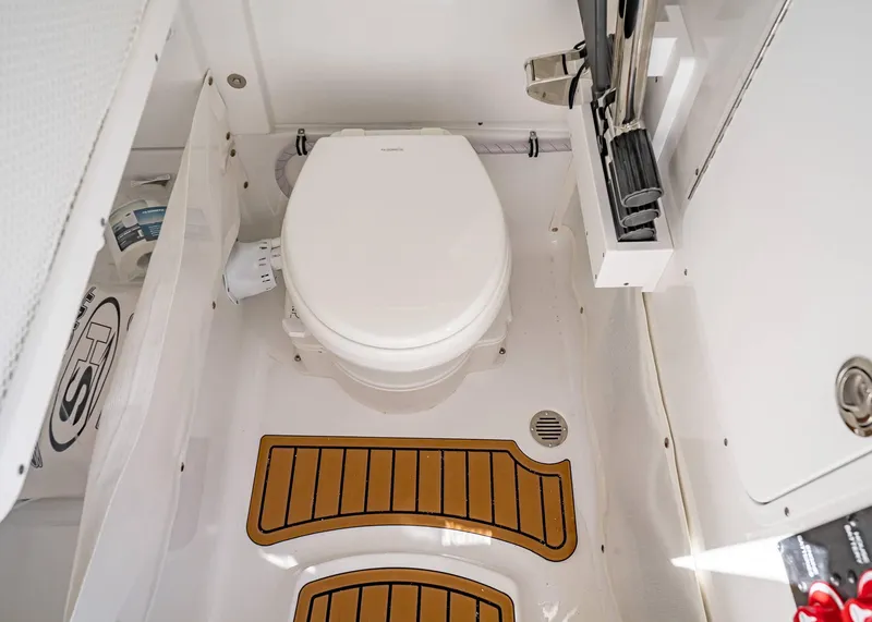 Slide: The Image of 2025 Sea Hunt Ultra 265 SE boat bathroom with toilet and storage compartments. - 33