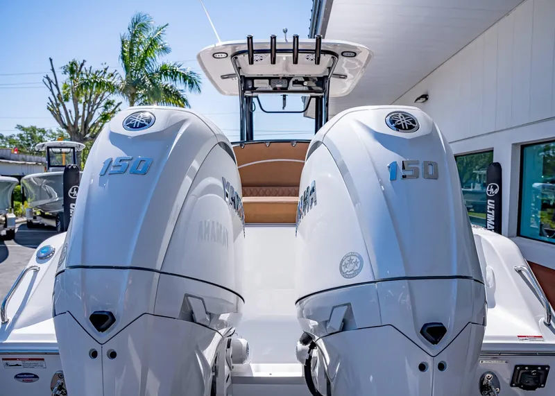 Slide: The Image of 2025 Sea Hunt Ultra 265 SE with dual Yamaha 150 engines, docked outdoors. - 5