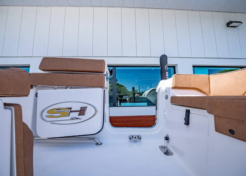Slide: The Image of 2025 Sea Hunt Ultra 265 SE boat interior with cushioned seating and logo. - 9