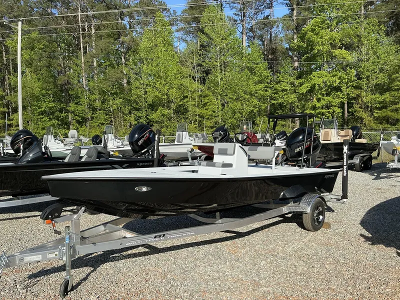 Slide: The Image of 2025 Xpress Skiff 185 boat on trailer in outdoor showroom. - 1
