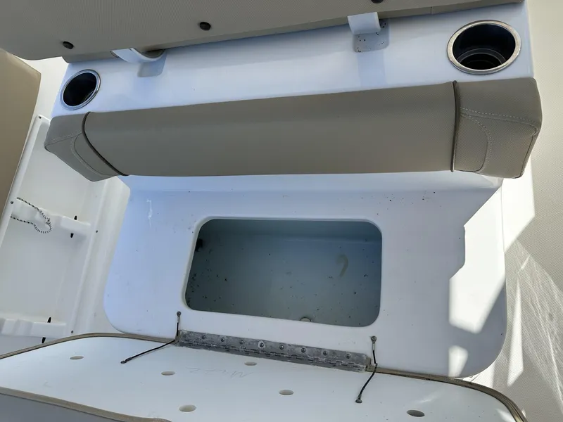 Slide: The Image of 2017 Sea Hunt Edge 24 boat seating area with storage compartment and cup holders. - 10