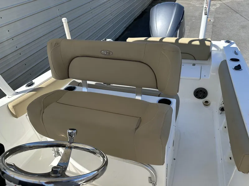 Slide: The Image of 2017 Sea Hunt Edge 24 boat interior with beige seating and steering wheel. - 11