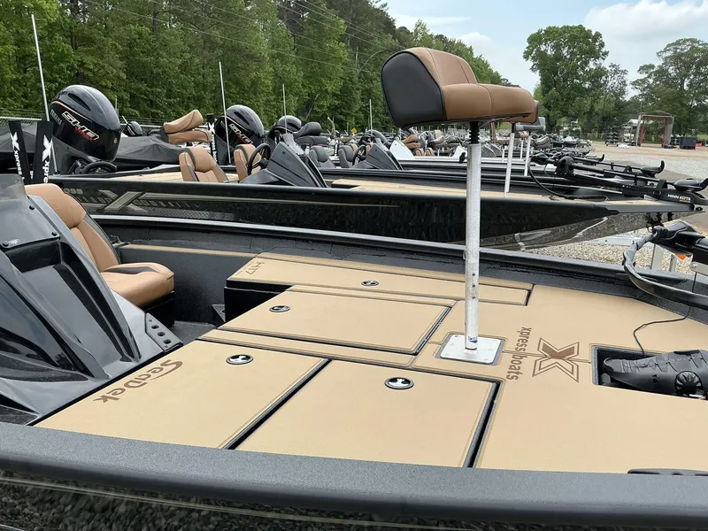 Slide: The Image of 2025 Xpress Hyper-Lift Bass Series boat with tan seating and storage compartments. - 4