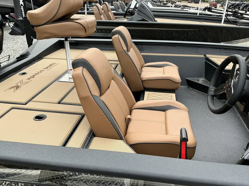 Slide: The Image of 2025 Xpress Hyper-Lift Bass Series boat interior with tan seats and steering wheel. - 7