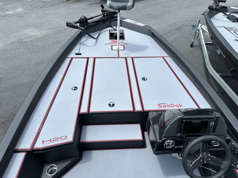 Slide: The Image of 2025 Xpress Hyper-Lift Bass Series boat deck with SeaDek flooring and steering console. - 4
