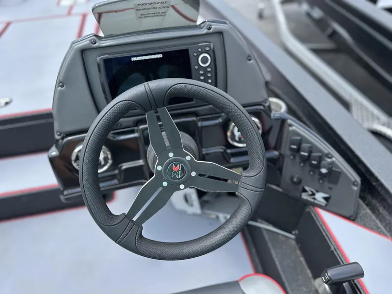 Slide: The Image of 2025 Xpress Hyper-Lift Bass Series boat dashboard with steering wheel and control panel. - 7