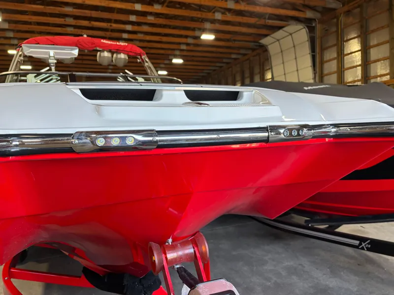 Slide: The Image of 2020 MasterCraft X24 boat in a garage, featuring a red and white hull. - 19