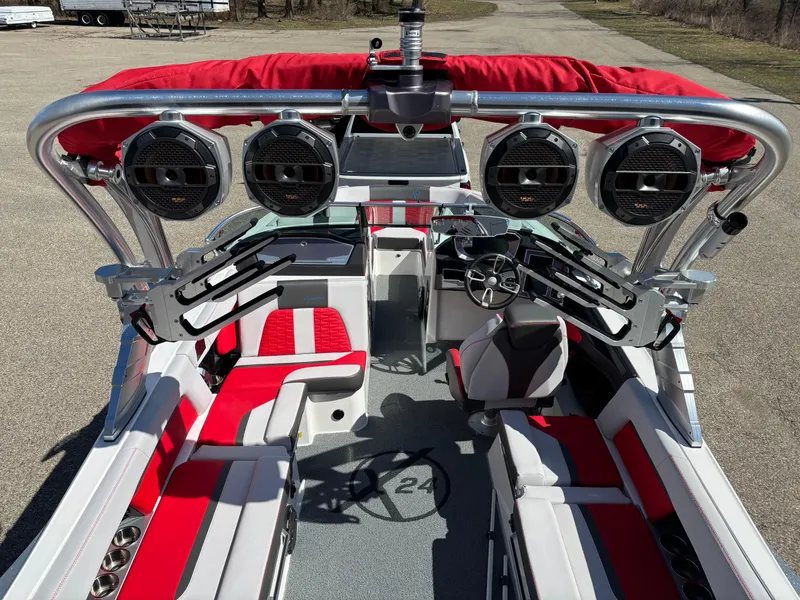 Slide: The Image of 2020 MasterCraft X24 boat interior with red and gray seating, advanced sound system, and steering console. - 7