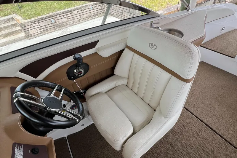 Slide: The Image of 2020 Cobalt 25SC boat interior with plush captain's chair and sleek steering wheel design. - 11