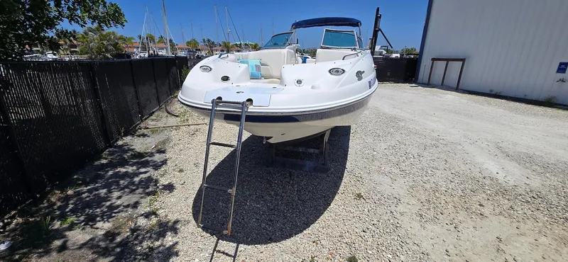Slide: The Image of 2006 Chaparral Sunesta 254 boat on gravel, with ladder and marina background. - 17