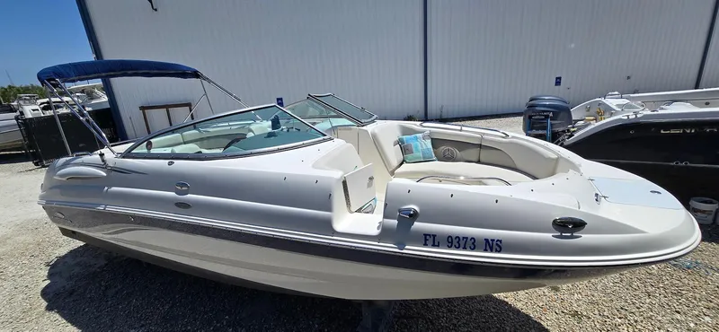 Slide: The Image of 2006 Chaparral Sunesta 254 boat with blue canopy, parked outdoors on gravel. - 20
