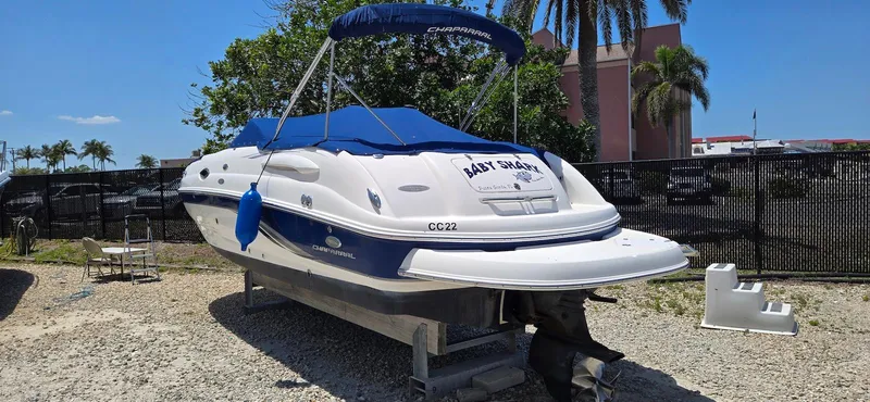 Slide: The Image of 2006 Chaparral Sunesta 254 boat with blue cover, parked on gravel. - 3
