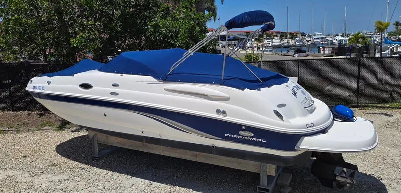 Slide: The Image of 2006 Chaparral Sunesta 254 boat with blue cover, docked near marina. - 6