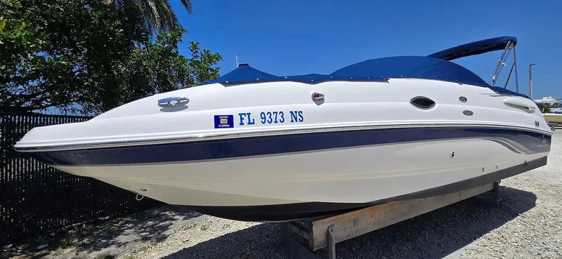Slide: The Image of 2006 Chaparral Sunesta 254 boat on trailer, white and blue, sunny day. - 7