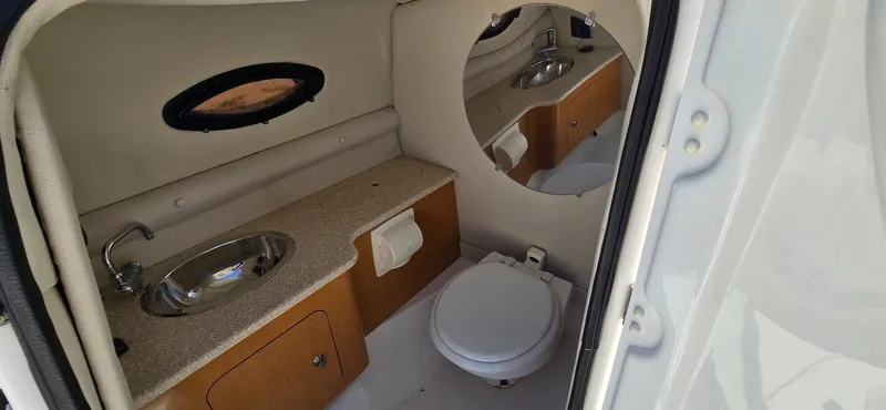 Slide: The Image of 2006 Chaparral Sunesta 254 boat bathroom with sink, toilet, and mirror. - 8