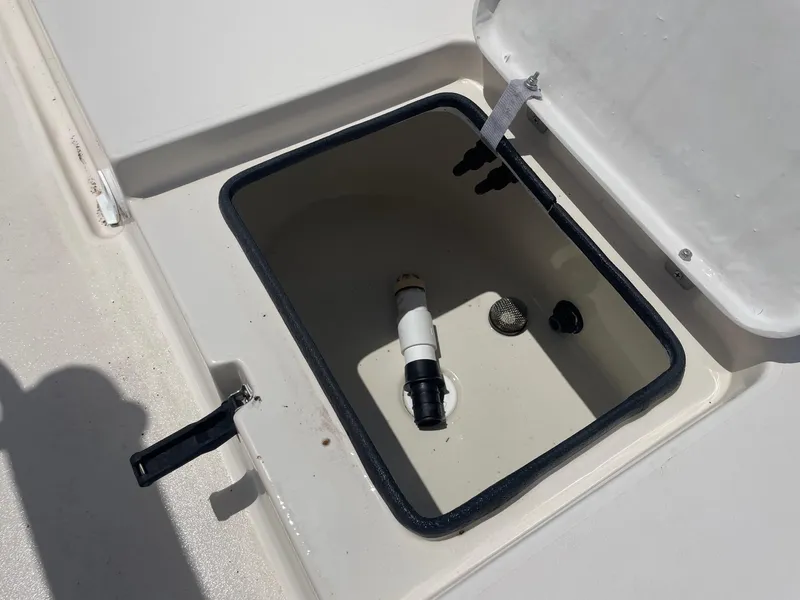 Slide: The Image of Open storage compartment on 2002 Pathfinder 2200v boat, showing interior fittings and latch. - 19