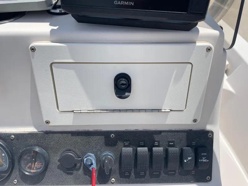 Slide: The Image of Control panel of a 2002 Pathfinder 2200v boat with switches and a Garmin device. - 26