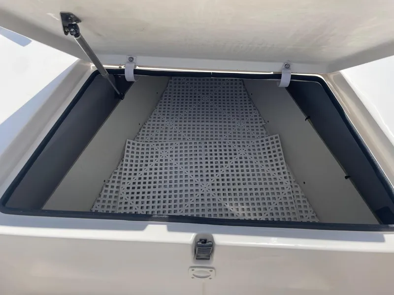 Slide: The Image of Open storage compartment on a 2002 Pathfinder 2200v boat, featuring a grid mat inside. - 37