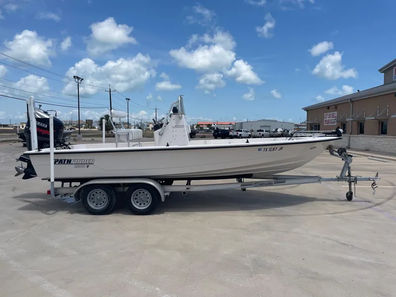 Slide: The Image of 2002 Pathfinder 2200v boat on trailer, parked outdoors under a clear blue sky. - 9
