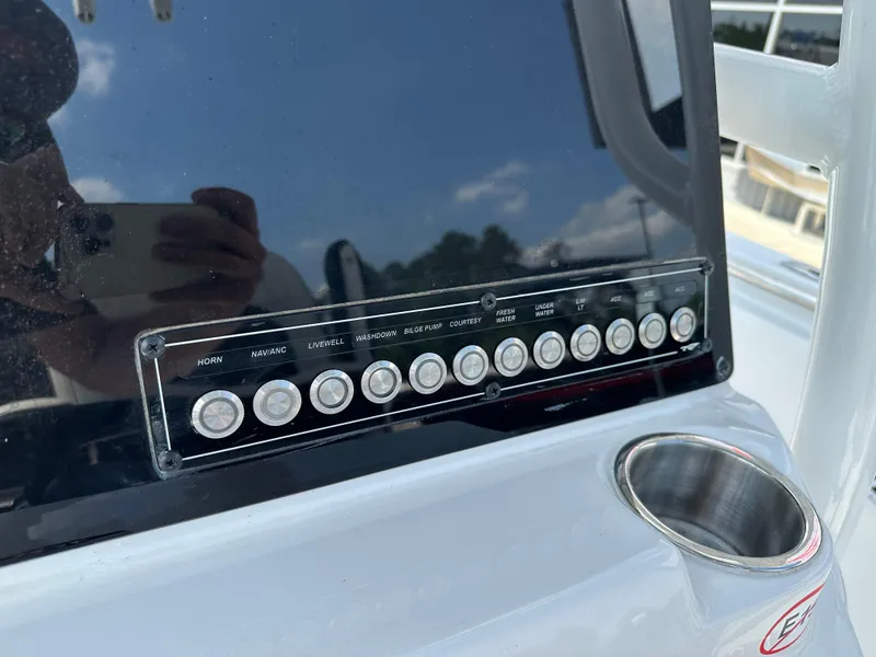 Slide: The Image of Control panel of 2025 Tidewater 210CC boat with labeled buttons and cup holder. - 13