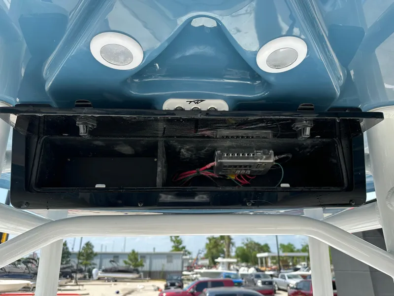 Slide: The Image of 2025 Tidewater 210CC boat electronics compartment with wiring and speakers. - 21