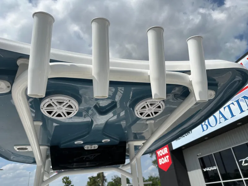 Slide: The Image of 2025 Tidewater 210CC boat with rod holders and speakers, under a cloudy sky. - 22