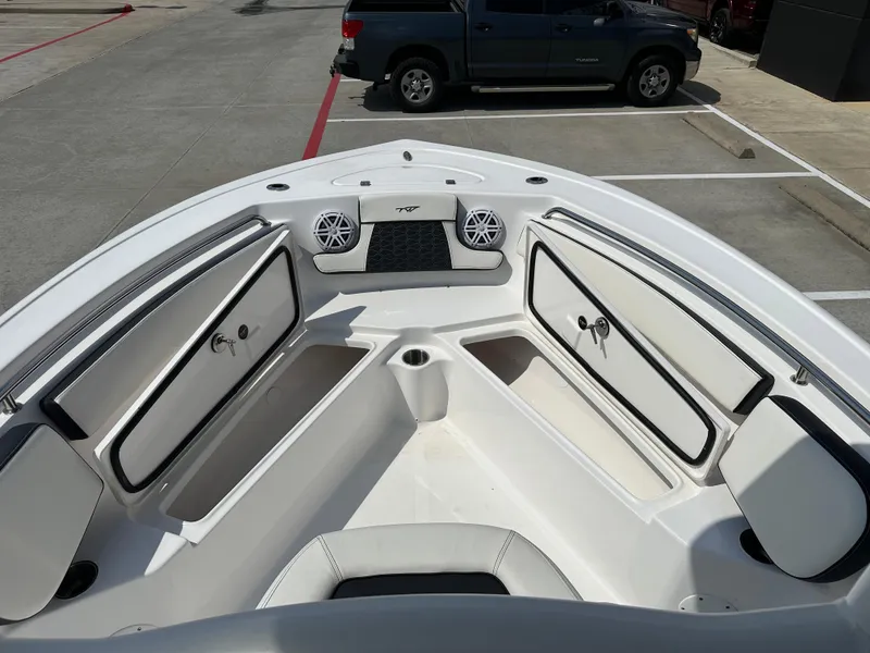Slide: The Image of 2025 Tidewater 210CC boat interior with open storage compartments and speakers. - 24