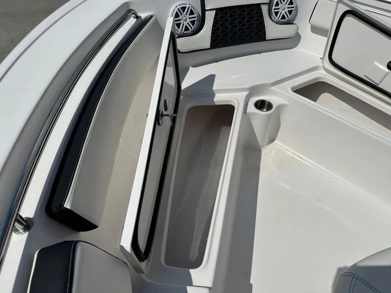 Slide: The Image of 2025 Tidewater 210CC boat interior with open storage compartment and cup holder. - 25