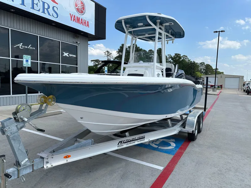 Slide: The Image of 2025 Tidewater 210CC boat on trailer outside dealership, featuring blue hull and T-top. - 3