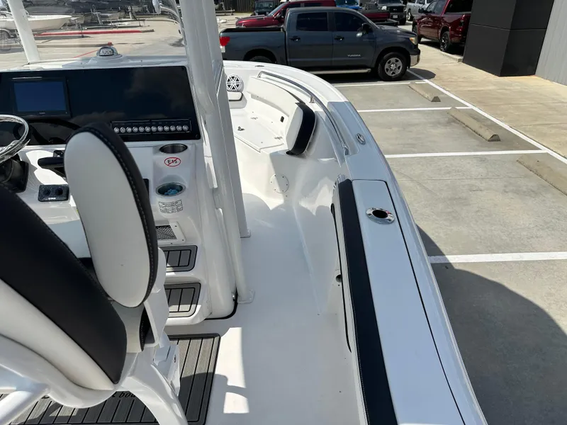 Slide: The Image of 2025 Tidewater 210CC boat interior with modern dashboard and seating in a parking lot. - 32