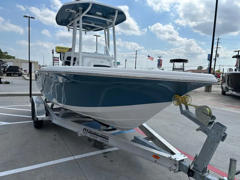 Slide: The Image of 2025 Tidewater 210CC boat on trailer under a cloudy sky in a parking lot. - 6