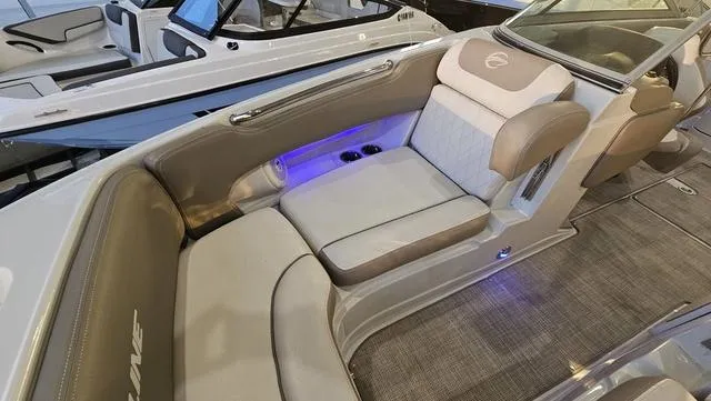 Slide: The Image of 2020 Crownline E 215 XS boat interior with cushioned seating and ambient lighting. - 20