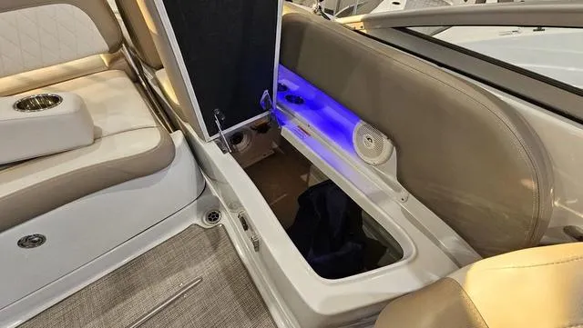 Slide: The Image of 2020 Crownline E 215 XS boat interior with open storage compartment and blue LED lighting. - 27